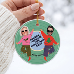 Hand holding a custom face cut photo ceramic Christmas ornament in a white knit sweater