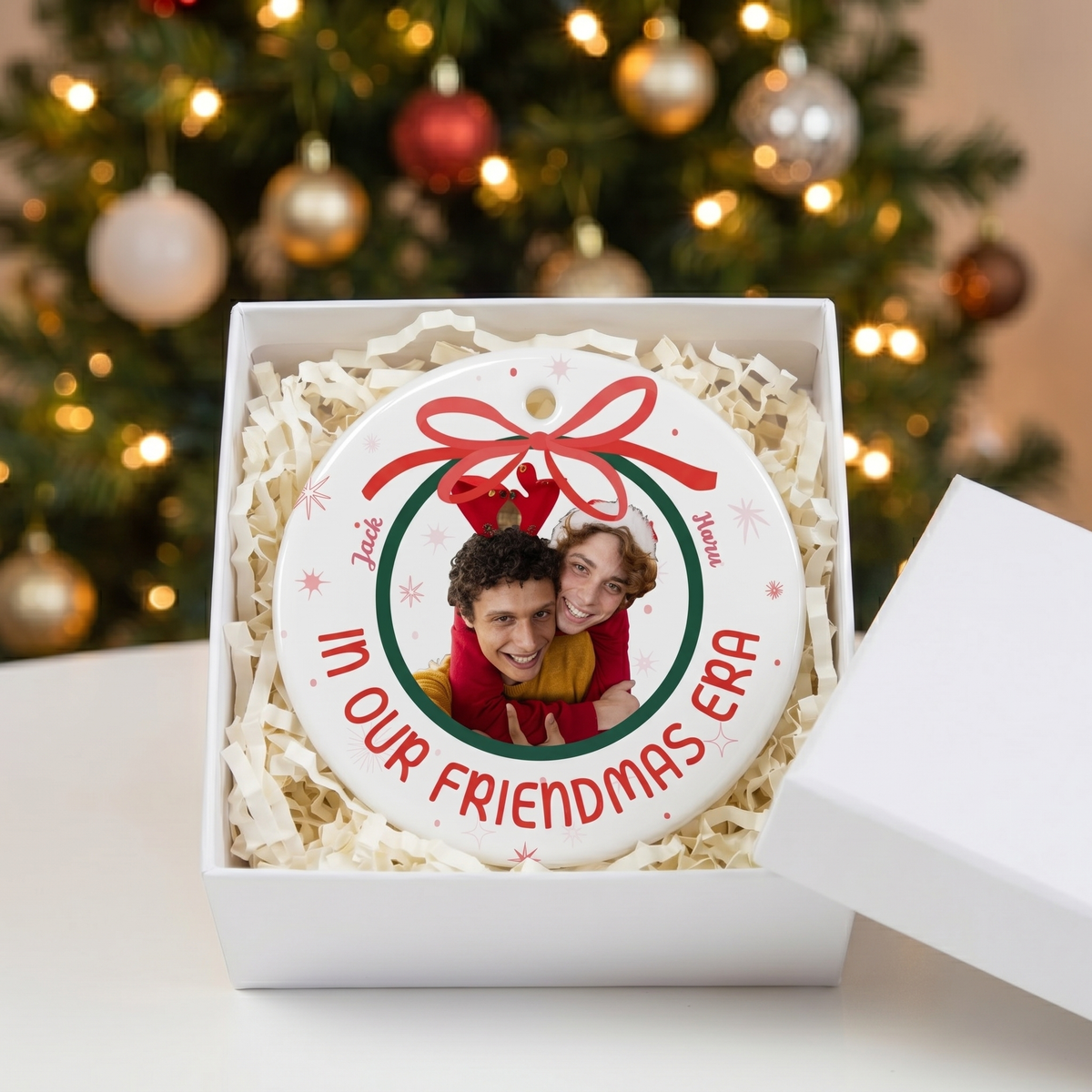 In Our Era ceramic Christmas ornament in an open white gift box with shredded paper