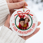 Hand holding an In Our Era ceramic Christmas ornament in a white knit sweater