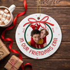 In Our Era ceramic Christmas ornament on a rustic wood table with cocoa