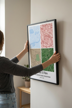 Person hanging a custom map wooden framed poster on a wall