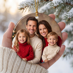 Hand holding a personalized family photo ceramic Christmas ornament with a snowy winter background