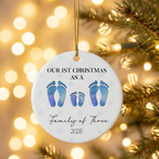 Personalized family of four footprint ceramic Christmas ornament against warm golden holiday bokeh