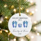 First Christmas as a family of four personalized footprint ceramic ornament hanging on a pine branch with holiday lights