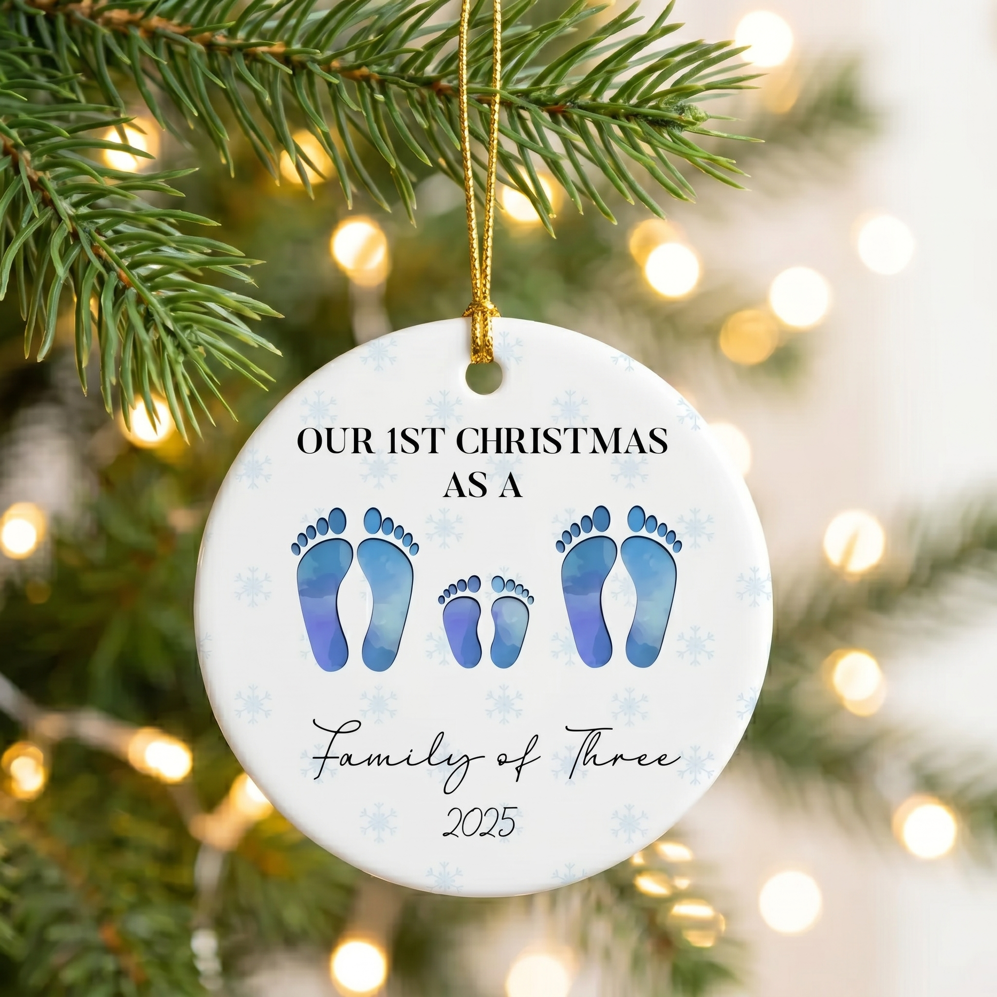First Christmas as a family of four personalized footprint ceramic ornament hanging on a pine branch with holiday lights