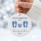 Hand holding a personalized family of four footprint ceramic Christmas ornament in a white knit sweater