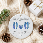 Family of four footprint ceramic Christmas ornament on a cream knit blanket with pine and a gift