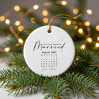 Our First Christmas Married personalized calendar ceramic ornament for Sabrina and Chris, August 2025, on a pine branch