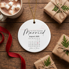 Our First Christmas Married calendar ceramic ornament on a rustic dark wood table with cocoa and wrapped gifts